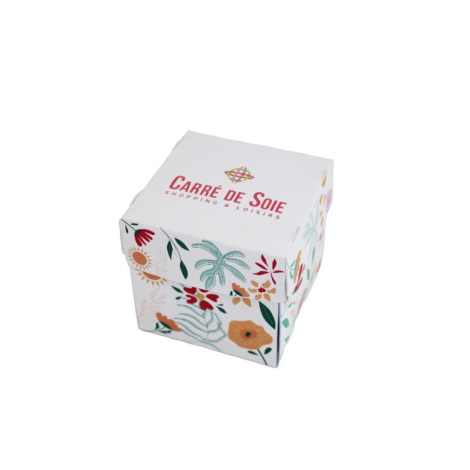 Boîte origami blanche décorée de motifs floraux colorés.
