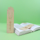 Marque-pages en bois clair posés sur un livre ouvert, certains avec marquage visible sur la face avant. Marque-pages en bois clair posés sur un livre ouvert, certains avec marquage visible sur la face avant.