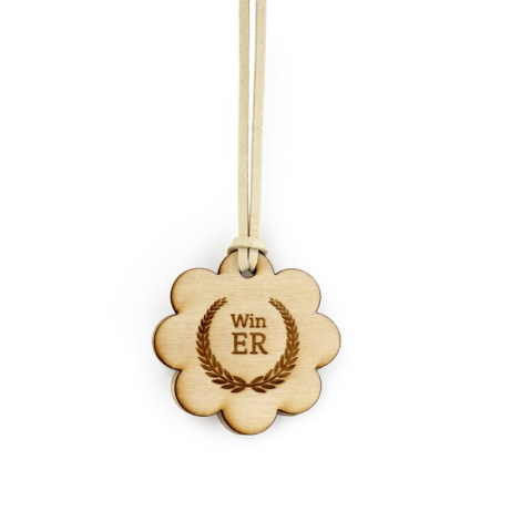 Médaillon en bois clair en forme de fleur suspendu par cordon beige, marquage visible sur la face bois.