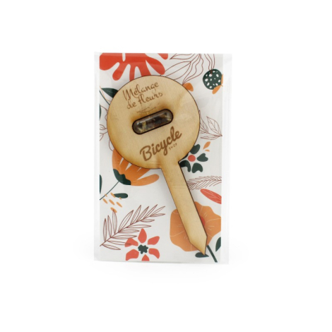 Pic en bois clair avec gélule insérée présenté dans un sachet transparent à fond floral coloré, marquage gravé visible.