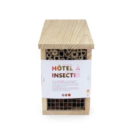 Hôtel à insectes rectangulaire en bois vu de face, compartiments intérieurs en tiges creuses derrière un grillage, étiquette pap