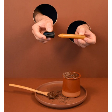 Crayon d’assaisonnement tenu au-dessus d’un dessert sur fond marron, sans personnalisation apparente.