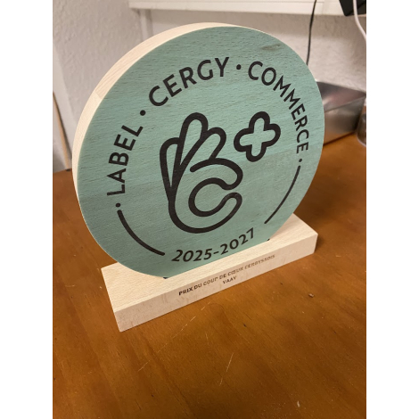 Trophée cercle en bois photographié sous un angle légèrement latéral, montrant l’épaisseur du disque et son insertion dans le so