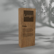 Trophée en bois rectangulaire présenté de face, zone rectangulaire plus sombre en partie supérieure et inscriptions visibles sur