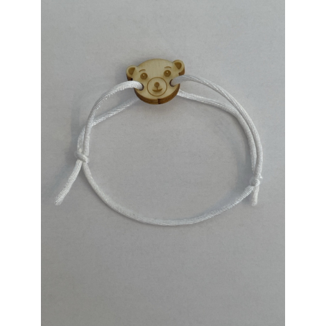 Bracelet en bois présenté seul sur fond clair avec cordon blanc ajustable, médaillon gravé en forme de tête d’ours visible de fa