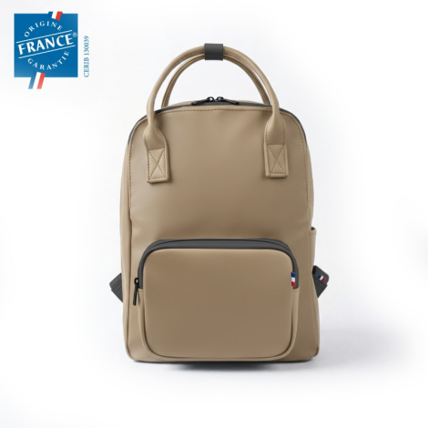 Sac à dos beige de face avec poignées ton sur ton et poche frontale contrastée zippée. Sans marquage visible.