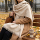 Écharpe beige clair en coton biologique portée en extérieur avec franges