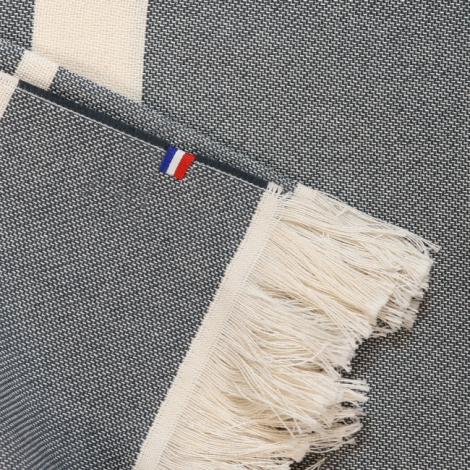 Gros plan fouta gris et blanc avec franges et étiquette cousue