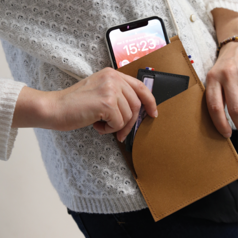 Pochette camel avec téléphone inséré, poche arrondie et coutures visibles, sans marquage visible