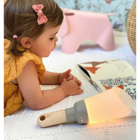 Enfant utilisant lampe nomade bois en situation lecture au sol