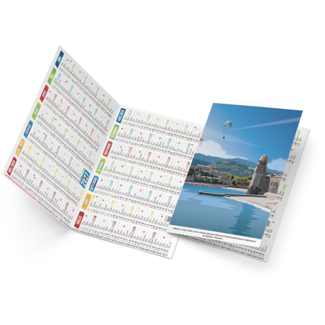 Calendrier de poche illustré avec paysage côtier, tour en bord de mer et planning annuel visible.