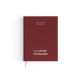 Agenda format voyage fermé avec couverture rouge effet naturel et signet textile blanc.