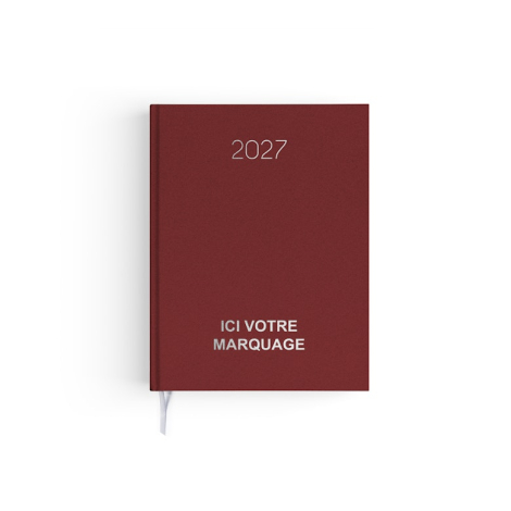 Agenda format voyage fermé avec couverture rouge effet naturel et signet textile blanc.