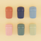 Mug réutilisable bleu à corps rainuré, ouvert et muni d’une paille métallique coudée, posé sur une nappe à carreaux lors d’un pi Mug réutilisable bleu à corps rainuré, ouvert et muni d’une paille métallique coudée, posé sur une nappe à carreaux lors d’un pi