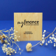 Sous-bock carré en bois personnalisé avec logo et coordonnées, présenté sur fond bleu avec des fleurs séchées.
