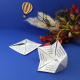 Cocottes en papier ensemencé personnalisées avec questions imprimées, mises en scène sur fond bleu.