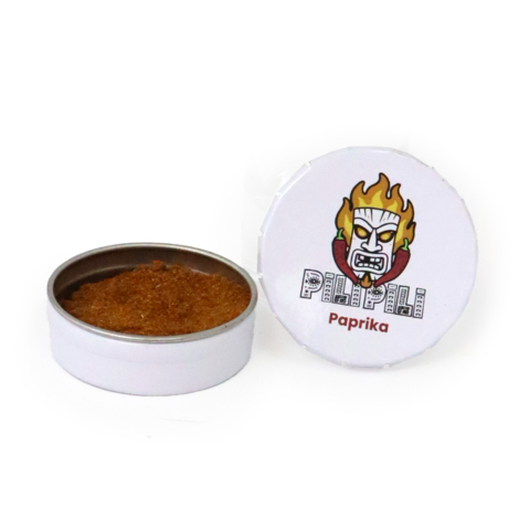Boîte ronde métallique personnalisée contenant du paprika, présentée ouverte sur fond blanc.