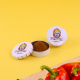 Boîtes rondes métalliques personnalisées pour épices, présentées avec herbes aromatiques et piment sur fond vert. Boîtes rondes métalliques personnalisées pour épices, présentées avec herbes aromatiques et piment sur fond vert.