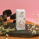 Boîte rectangulaire personnalisée en papier ensemencé avec logo et motifs végétaux, mise en scène avec des fleurs séchées sur fo