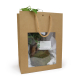 Kokedama conditionné dans un sac cadeau en kraft avec fenêtre transparente et fiche d’entretien.